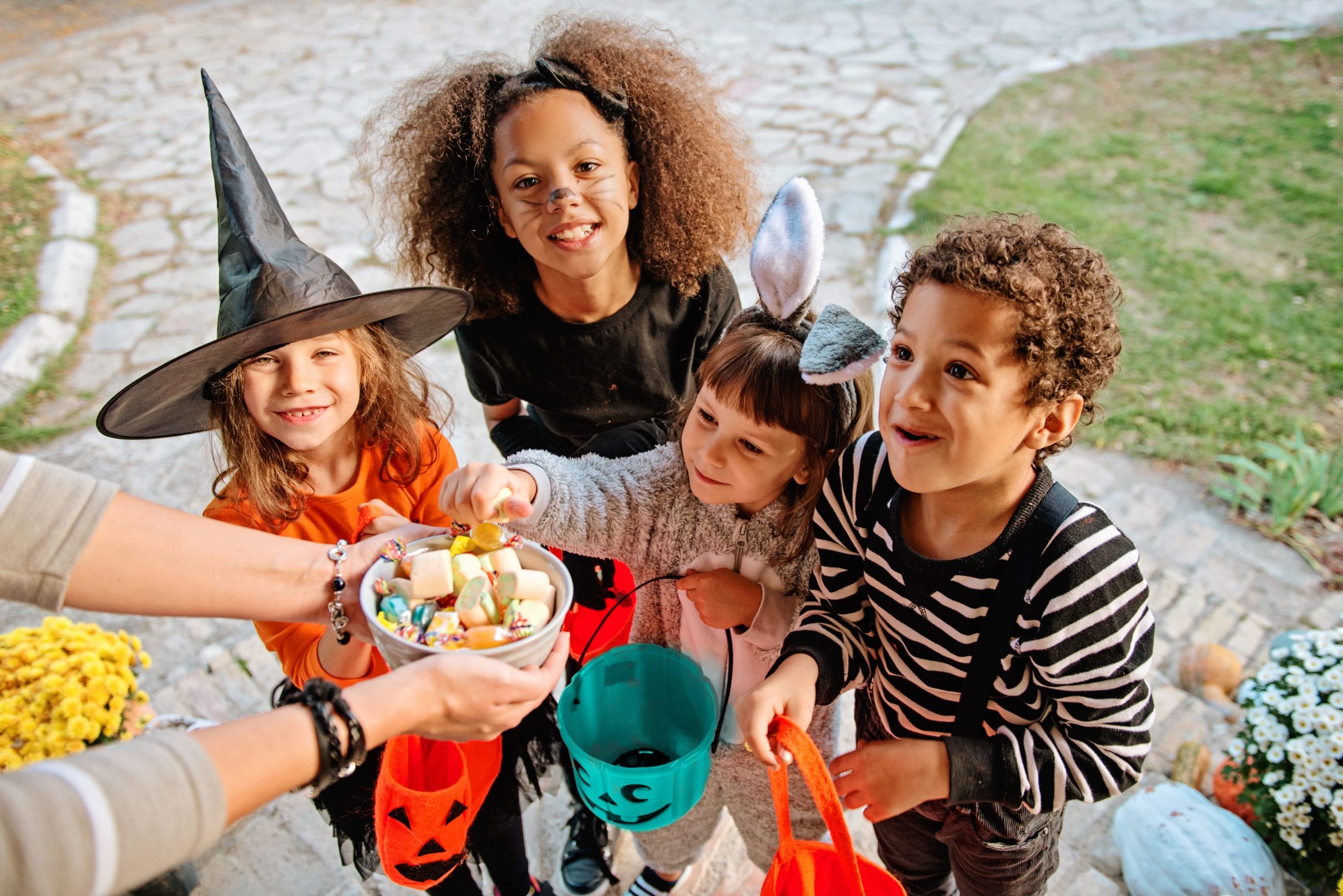 four children collecting candy while trick or treating